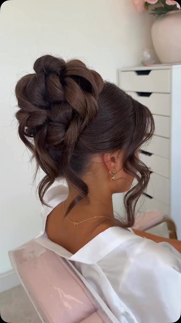 Woman with an elegant brown hair updo wearing a white satin robe.
