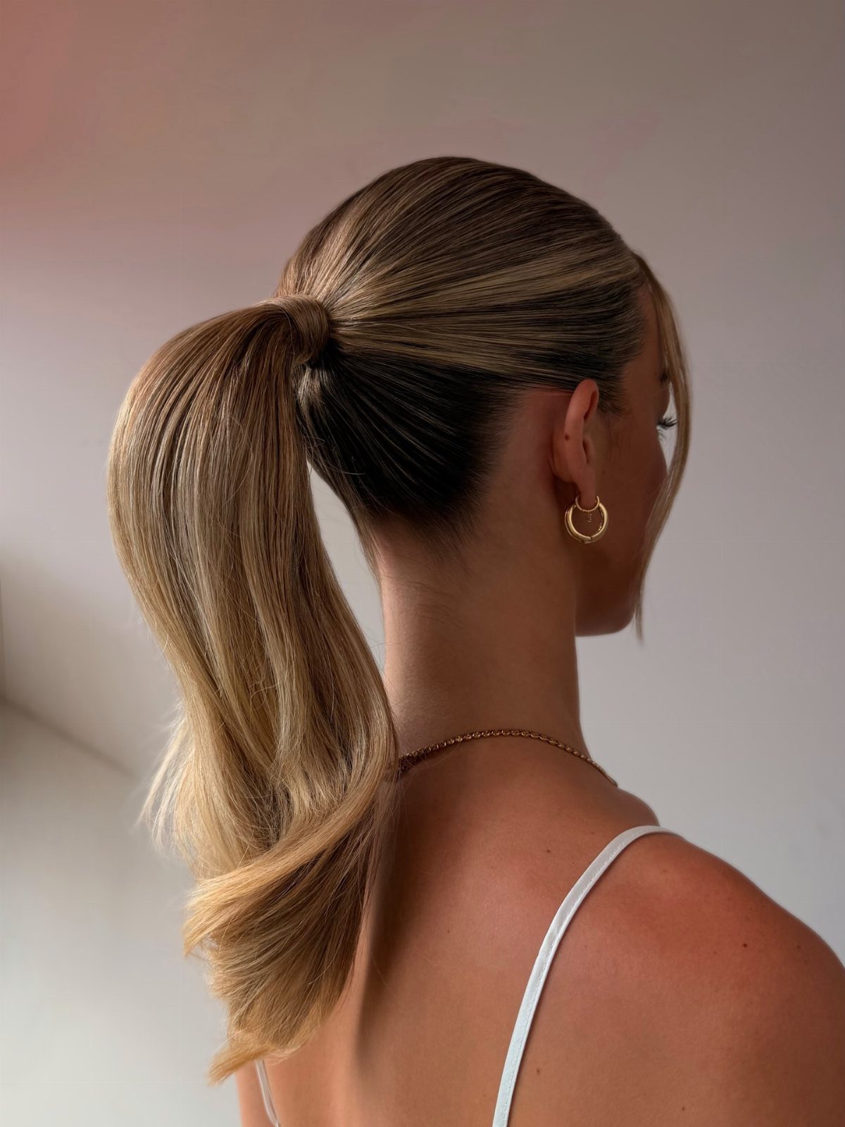 Blonde hair styled in a high sleek ponytail with a polished finish.