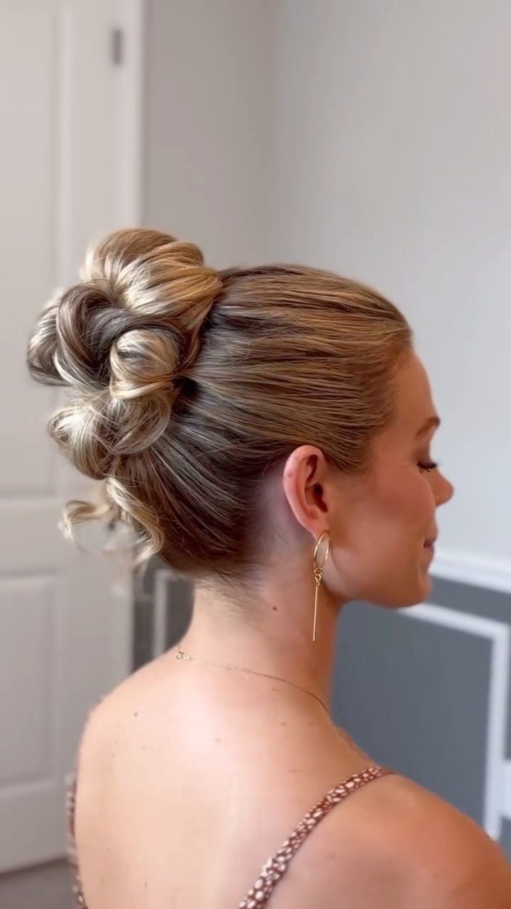 Woman with blonde hair styled in a high textured bun and beaded dress.