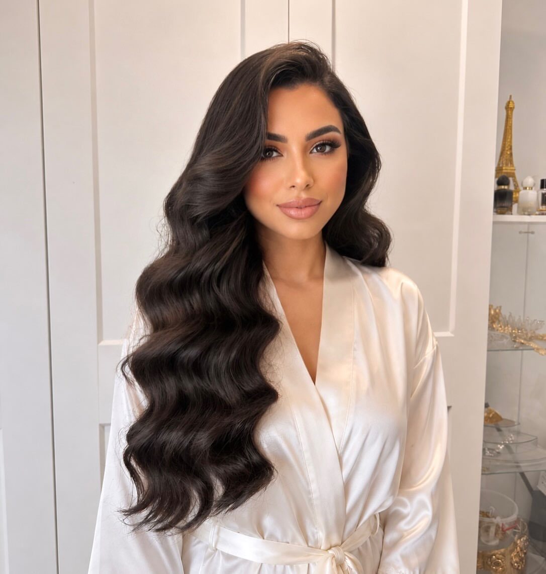 Woman with long dark brown hair styled in voluminous, polished romantic waves