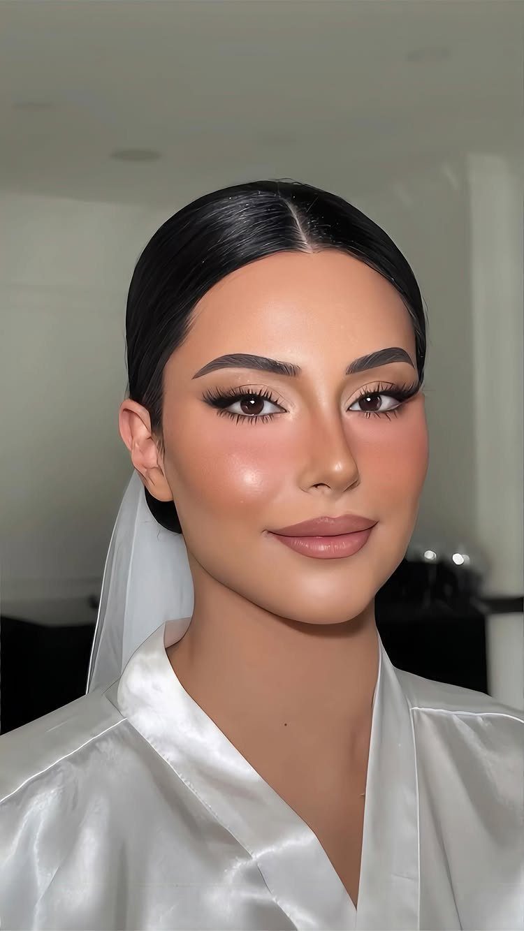 Woman in bridal attire with polished natural makeup and long defined eyelashes.