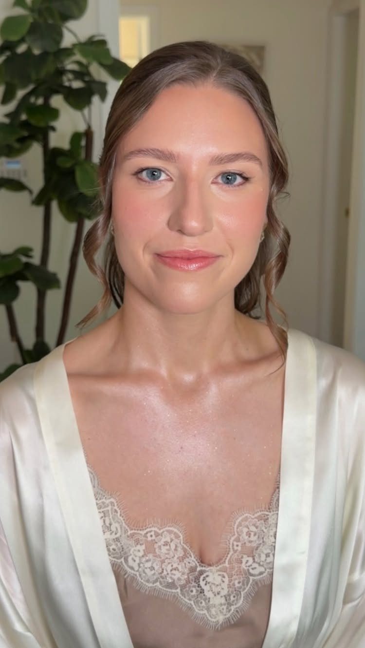 Woman with natural bridal makeup wearing a white satin robe and lace lingerie