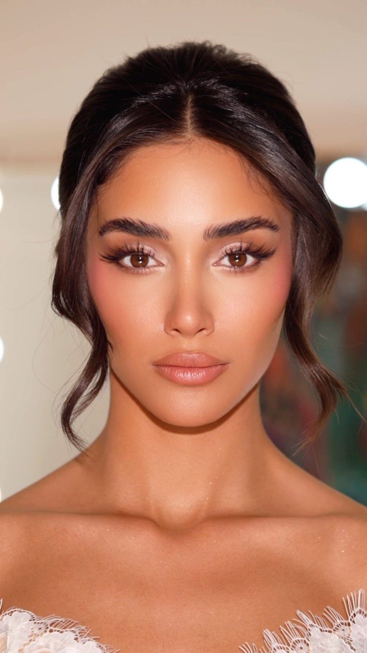 Woman with bridal makeup featuring neutral blush shades and a soft glowy finish.