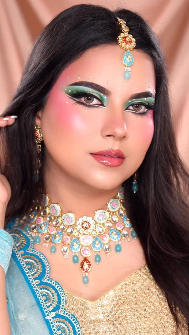 Woman with dramatic green and pink eyeshadow and ornate gold bridal jewelry