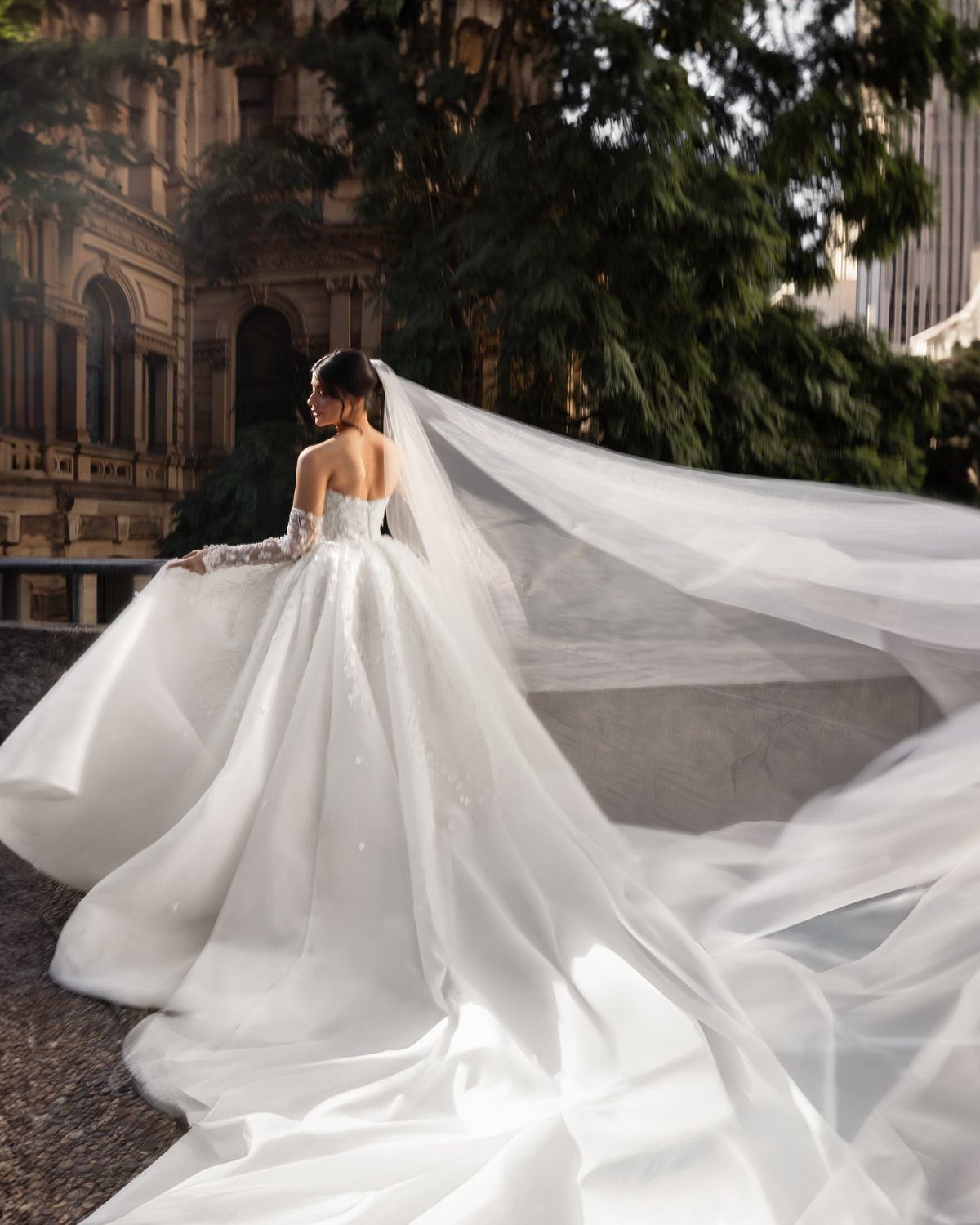 Bride in a white gown with a long veil flowing in the wind