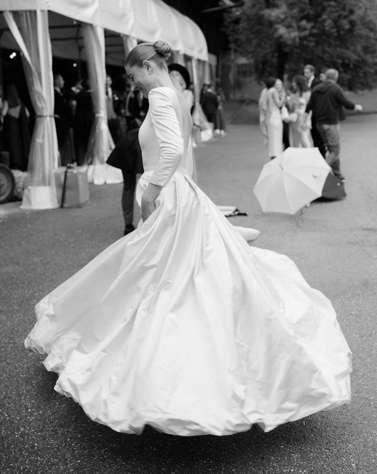 Bride in a white wedding gown spinning, making her full skirt flare out.
