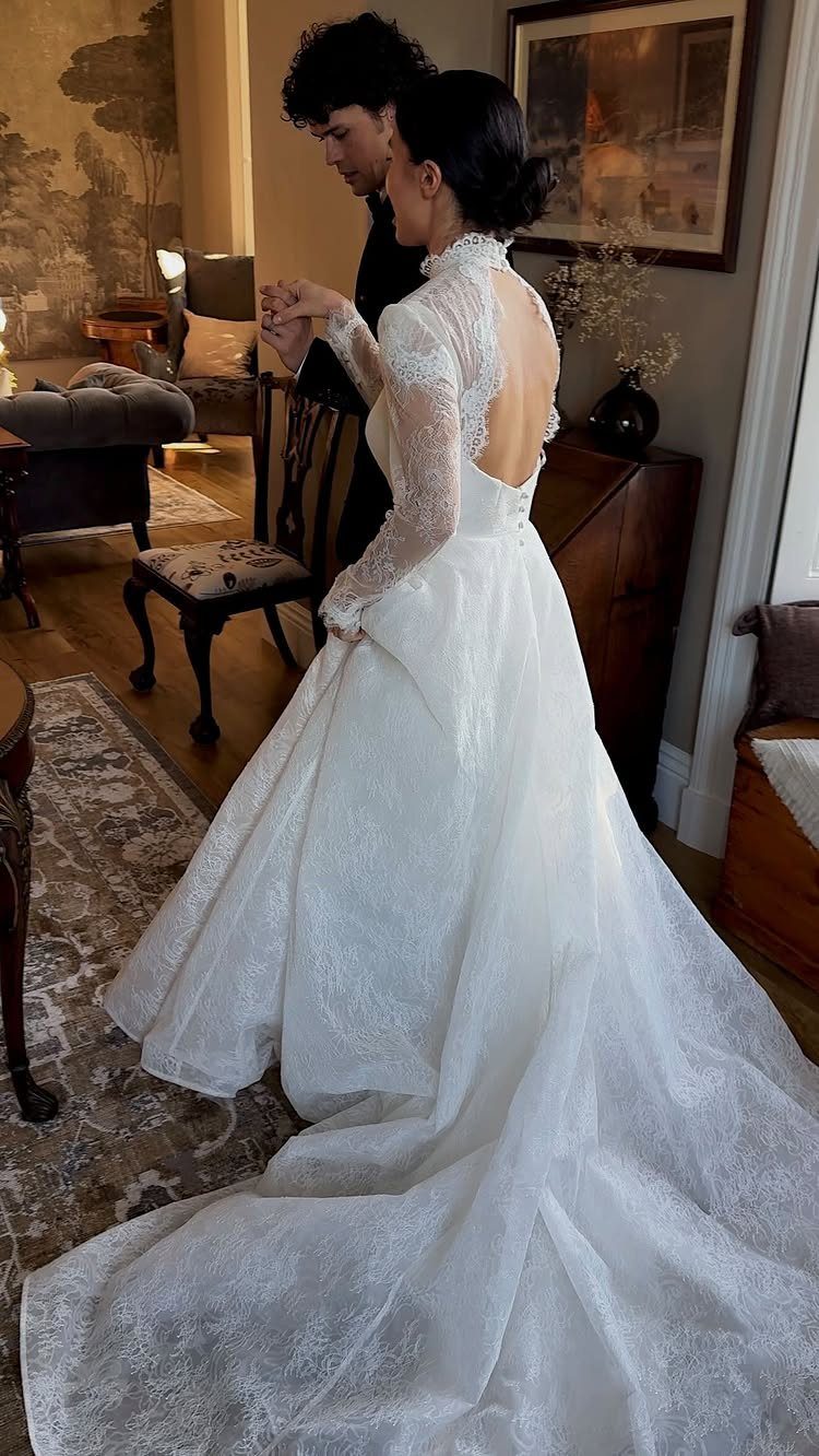 Bride and groom dancing together in a living room during their wedding celebration.