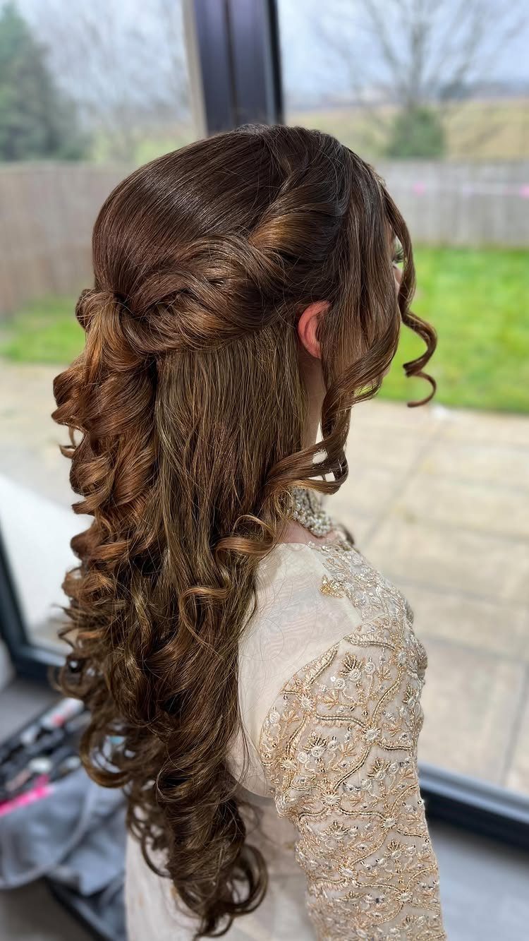 Brown curly hair styled half-up half-down with cascading ringlets and gold embroidered dress.