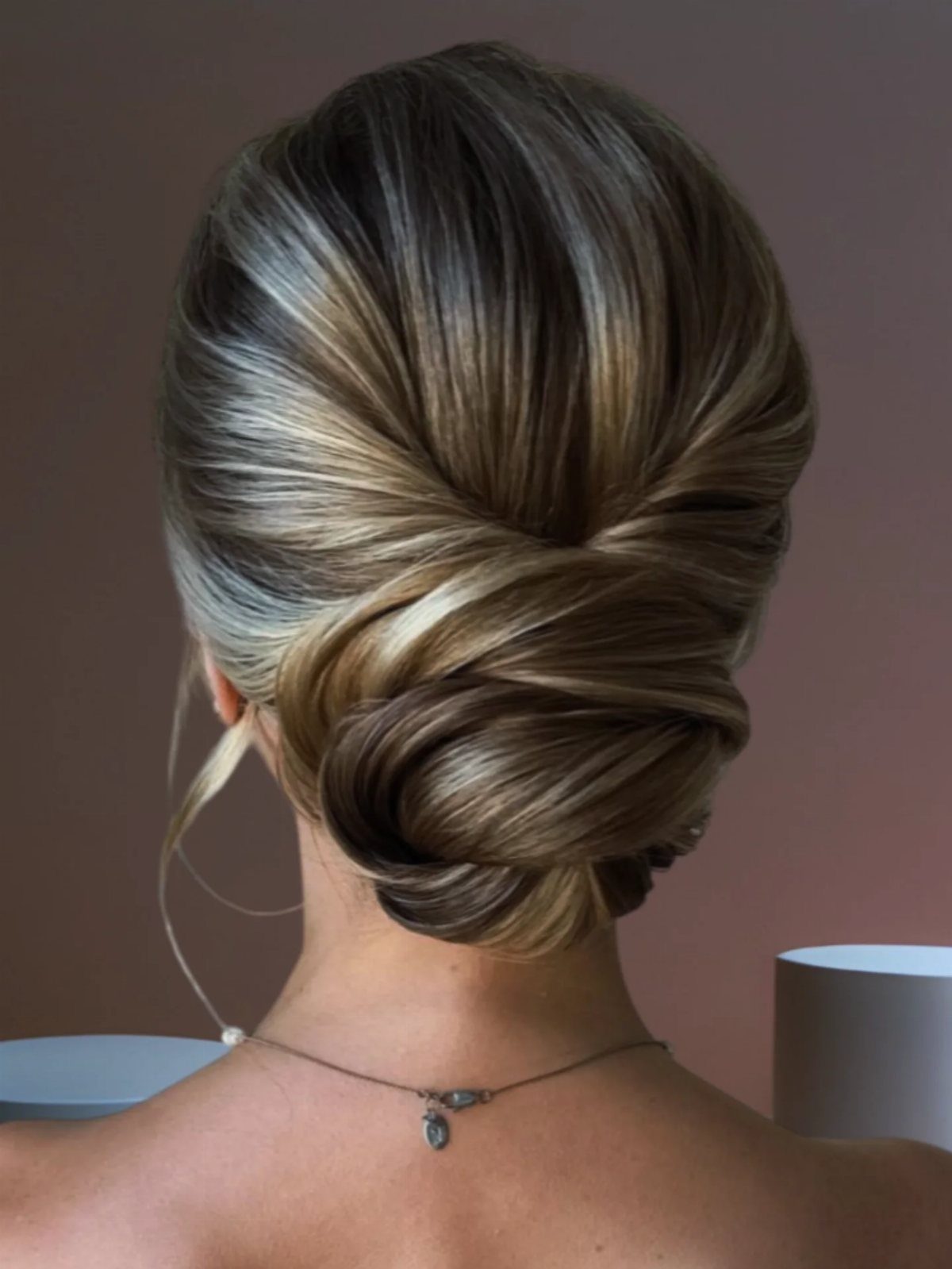 Low twisted wedding bun with blonde highlights on the back of a head