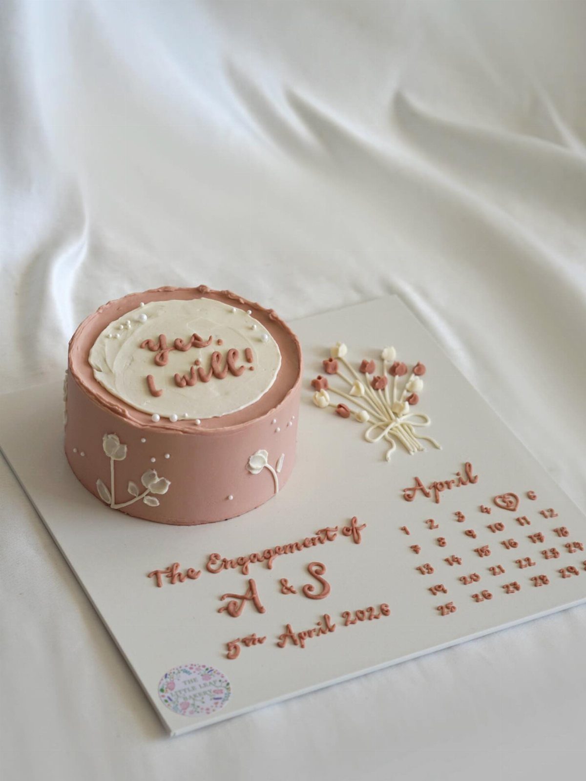 Dusty rose engagement cake with a calendar and 'yes, I will!' text.