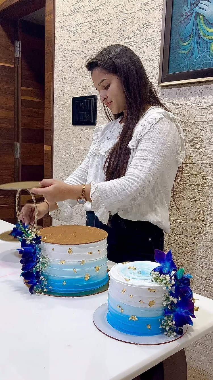 Two blue and white ombré cakes decorated with blue flowers and gold leaf.