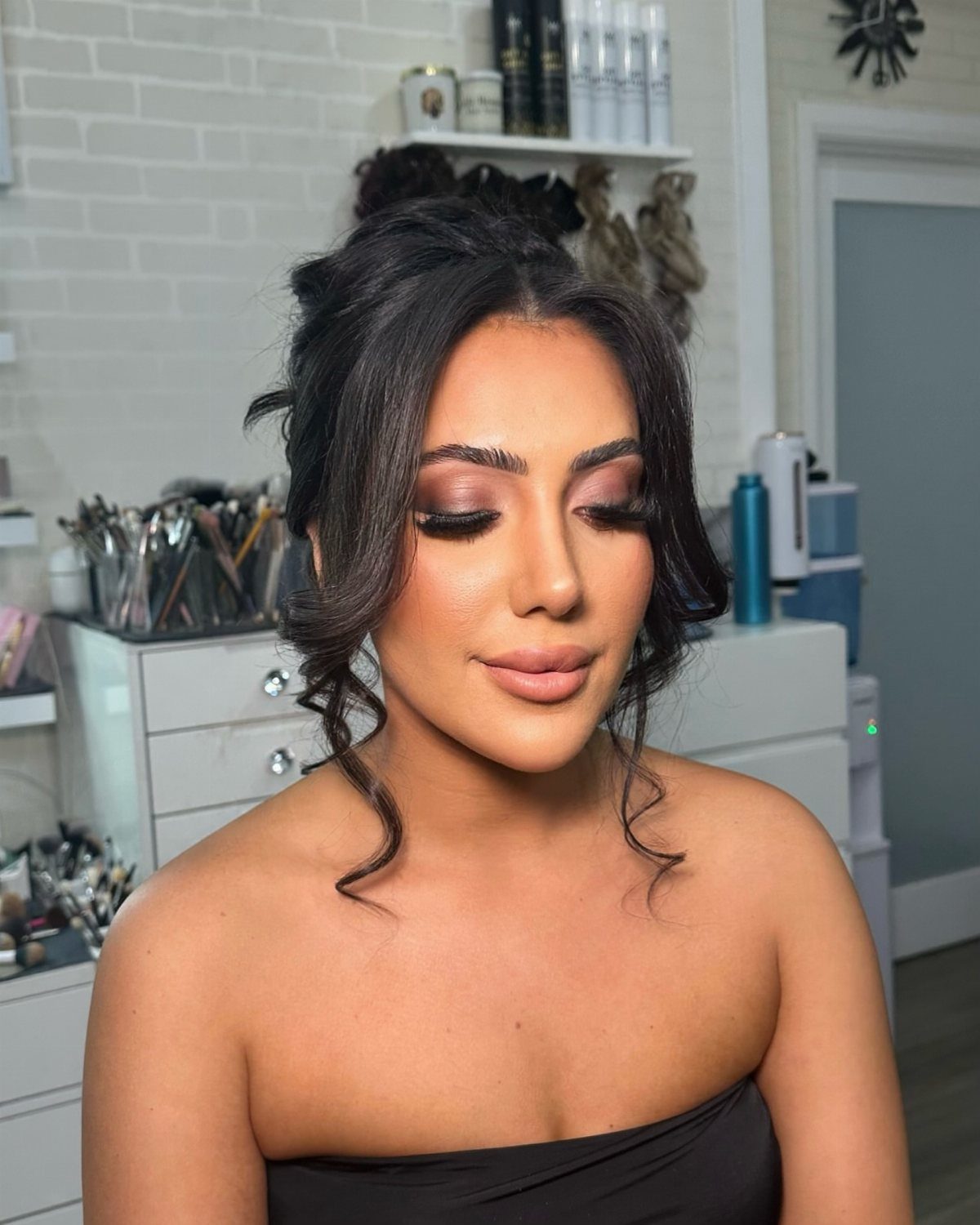 Woman with glamorous bronze eyeshadow and nude lips posing for a portrait.