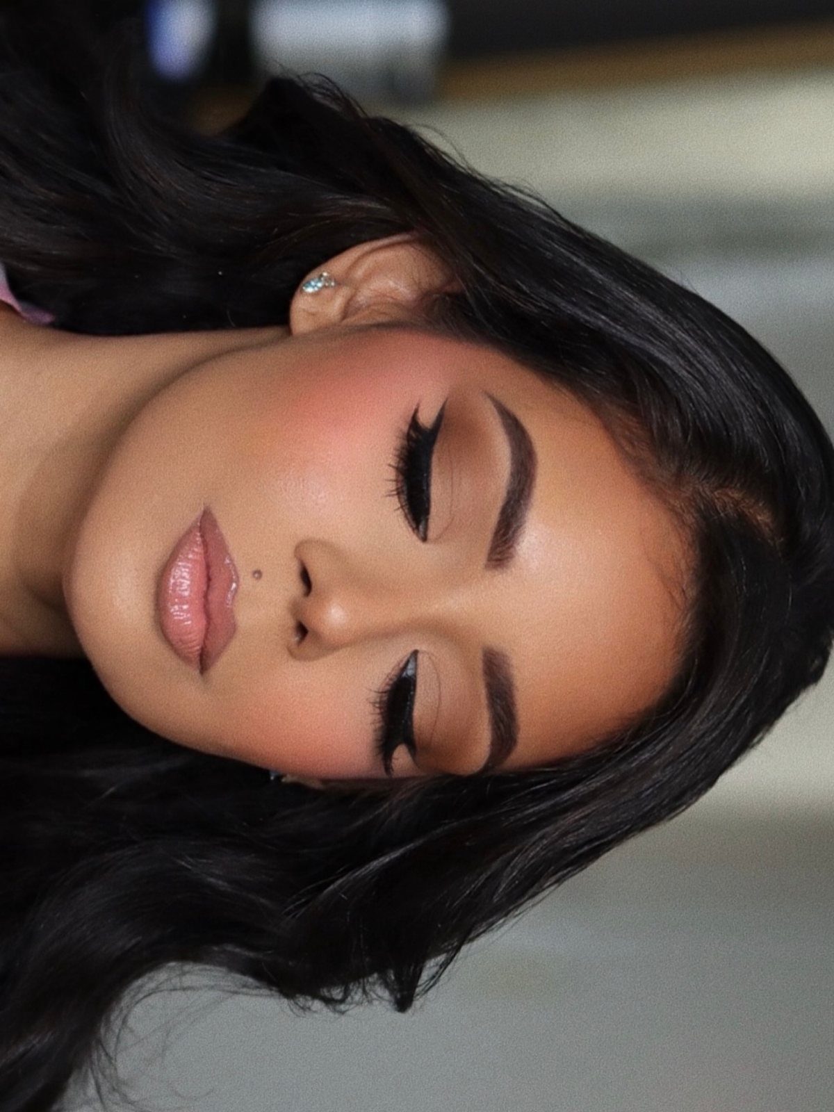 Woman with full glam makeup featuring perfectly defined, sculpted dark eyebrows and lashes.