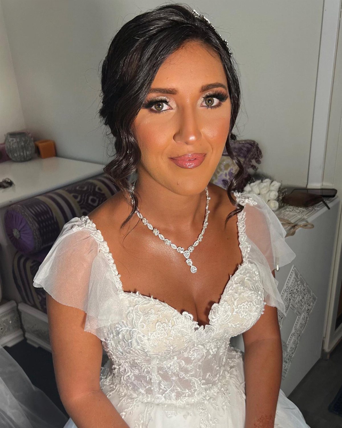 Bride with glowing highlighter on her cheeks and nose wearing a white dress