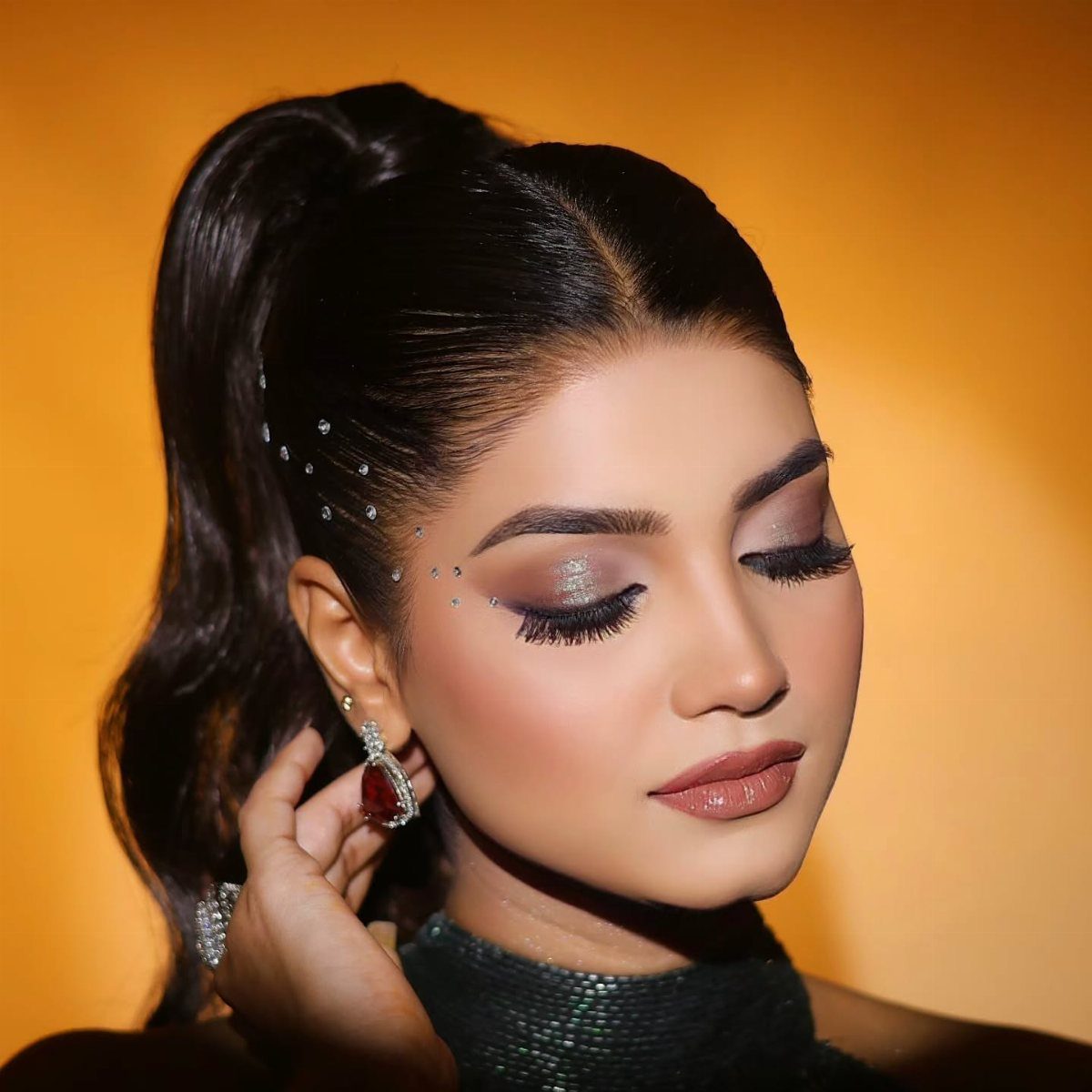 Woman with shimmering silver smoky eyeshadow, long false lashes, and nude lipstick.