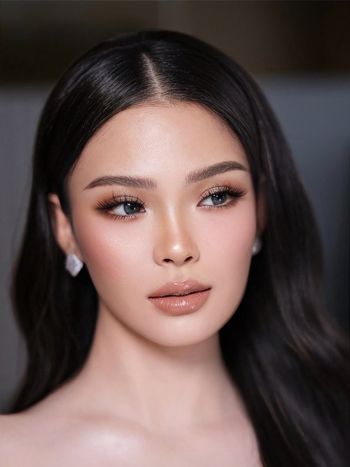 Woman with soft glam wedding makeup, neutral tones, and glossy nude lips.