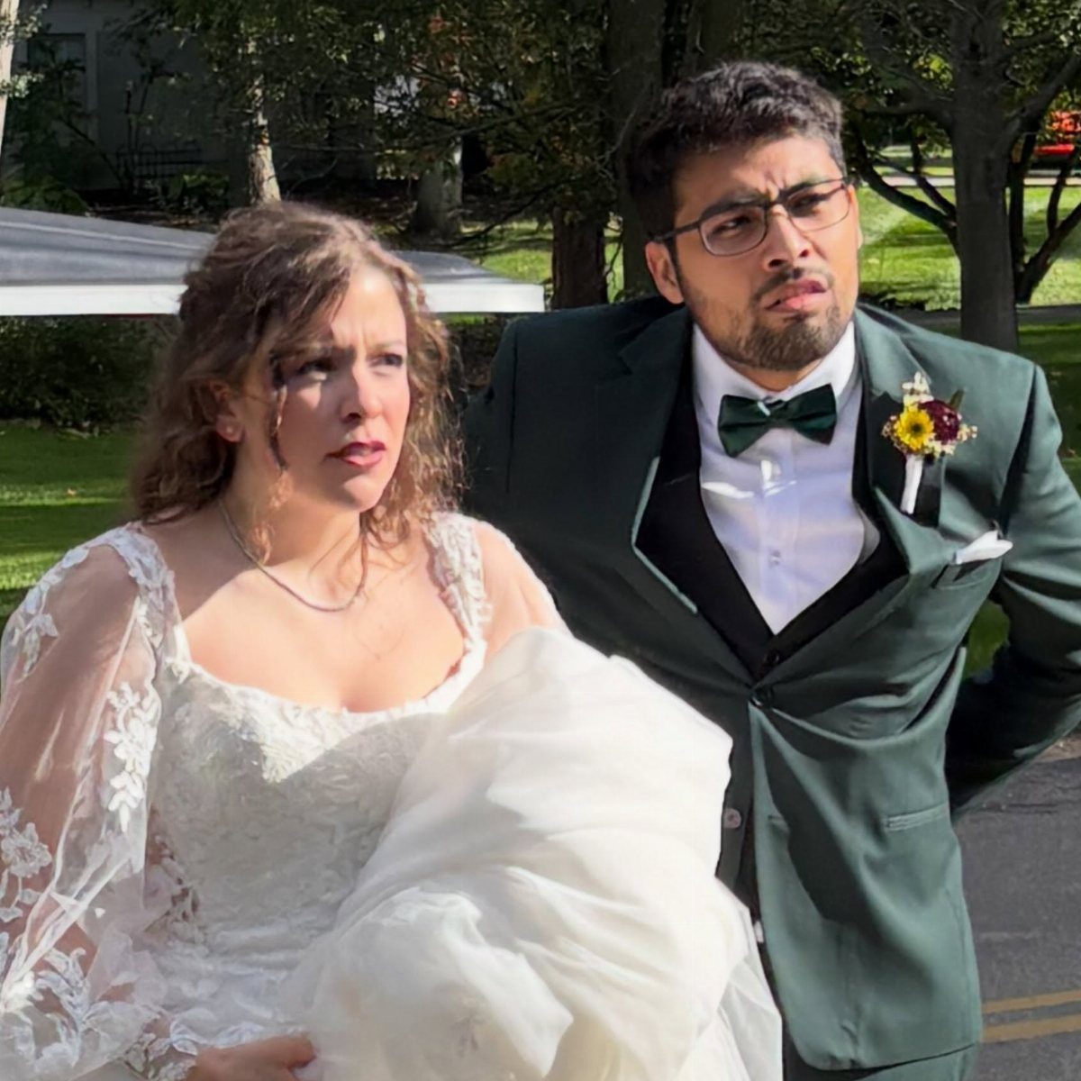 Bride and groom making silly, confused faces while posing outdoors in wedding attire.