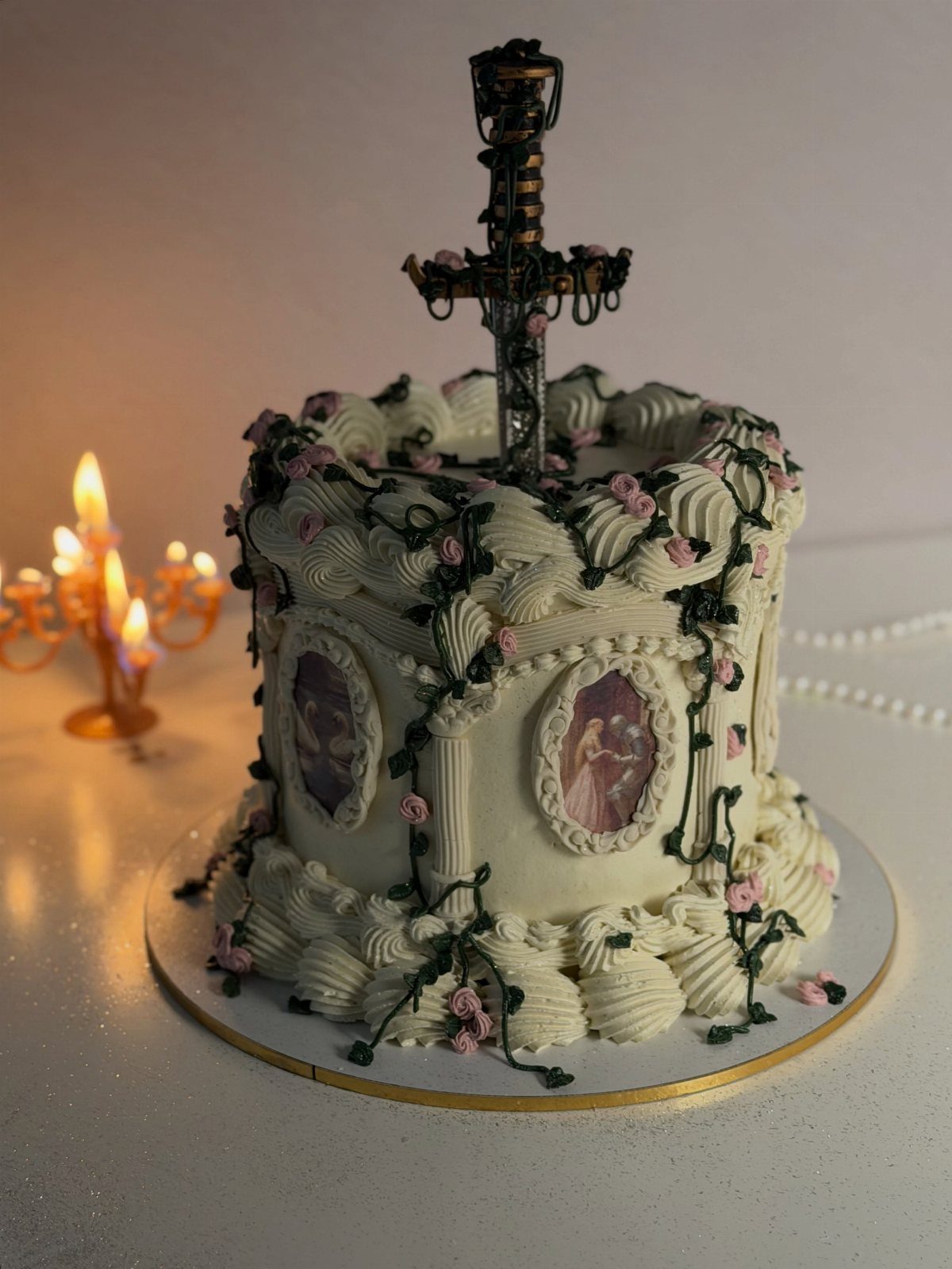 White cake with pink roses and a black sword plunged into the top.