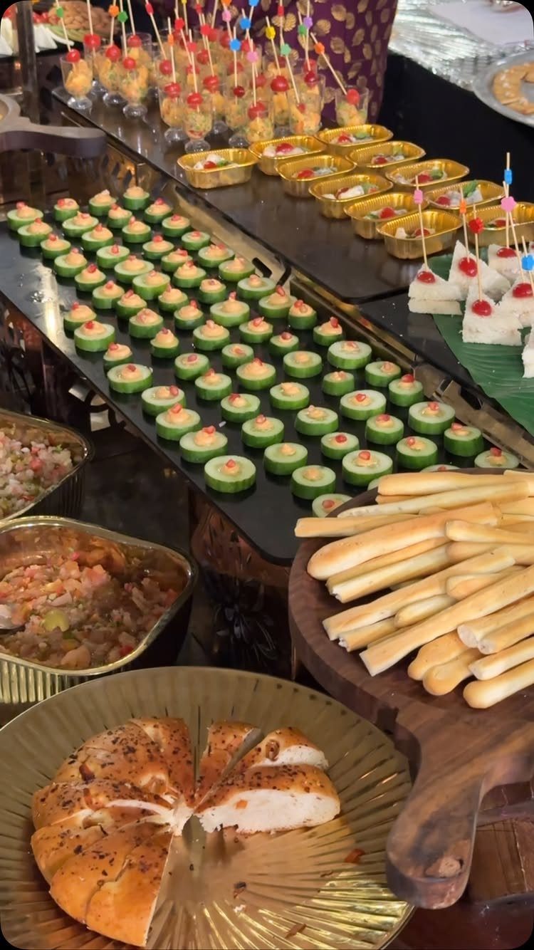Assorted appetizers and breadsticks arranged on tiered platters for a self-service buffet.