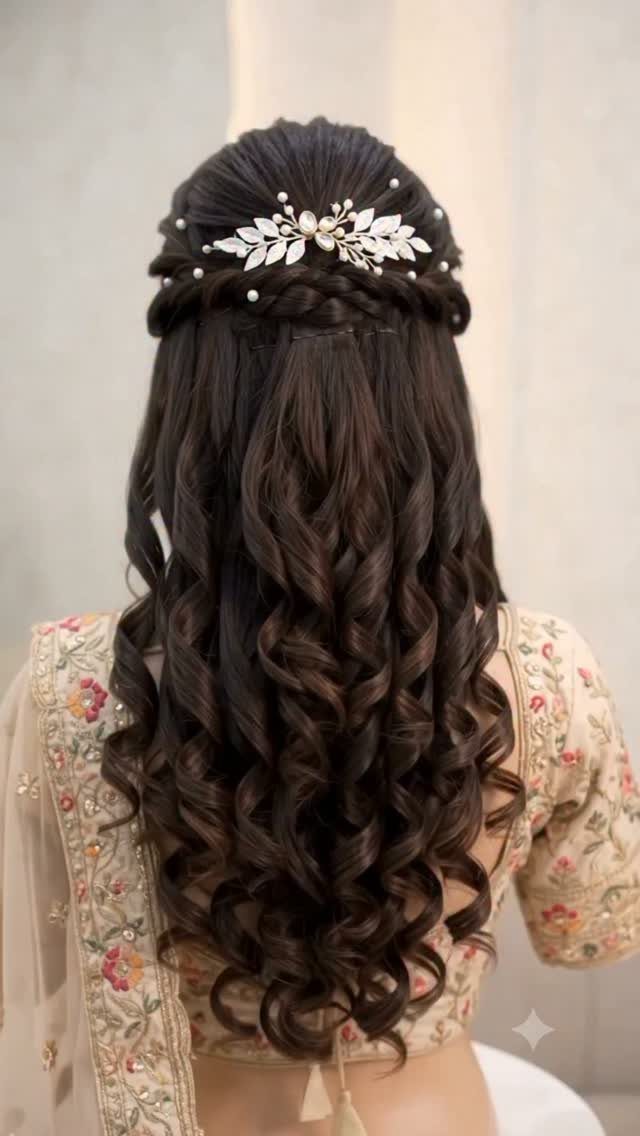 Long dark brown spiral curls with a silver leaf hair accessory and pearls.