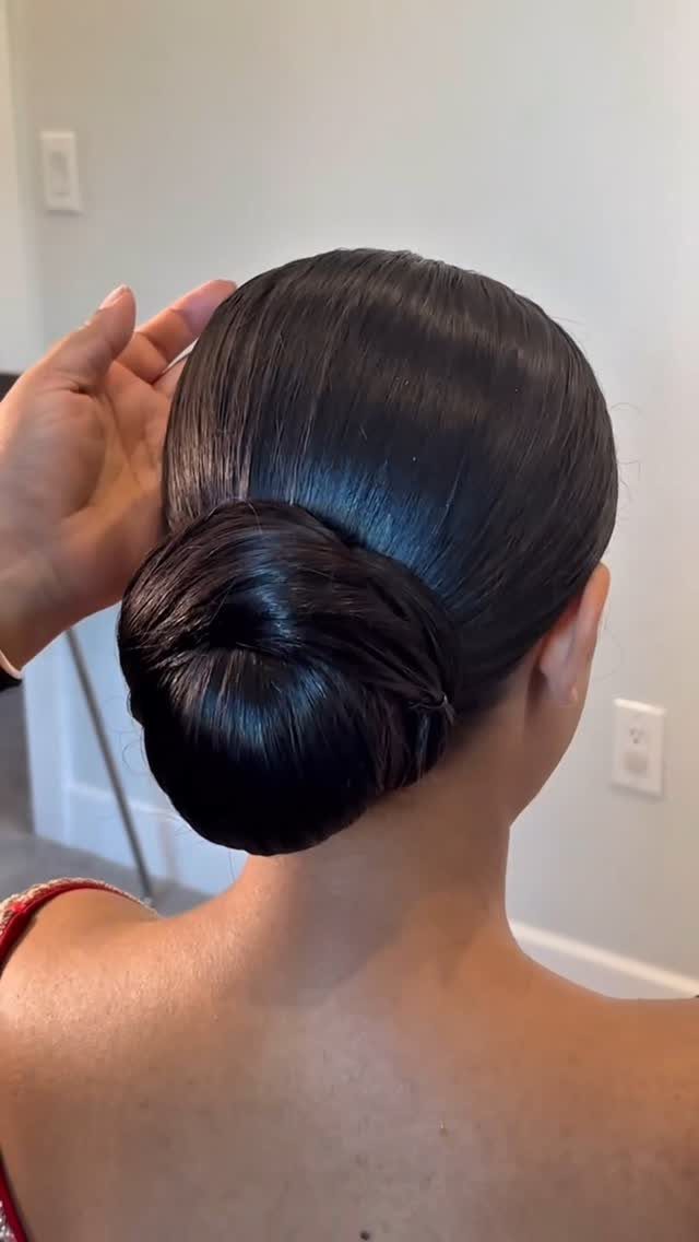Sleek low bun hairstyle on dark hair, polished and neat back view.