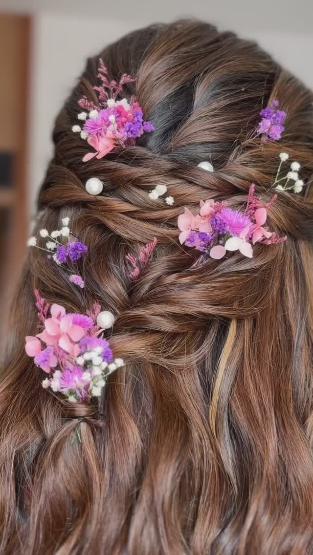 Brown hair in a twisted knot with pink and purple floral accents.