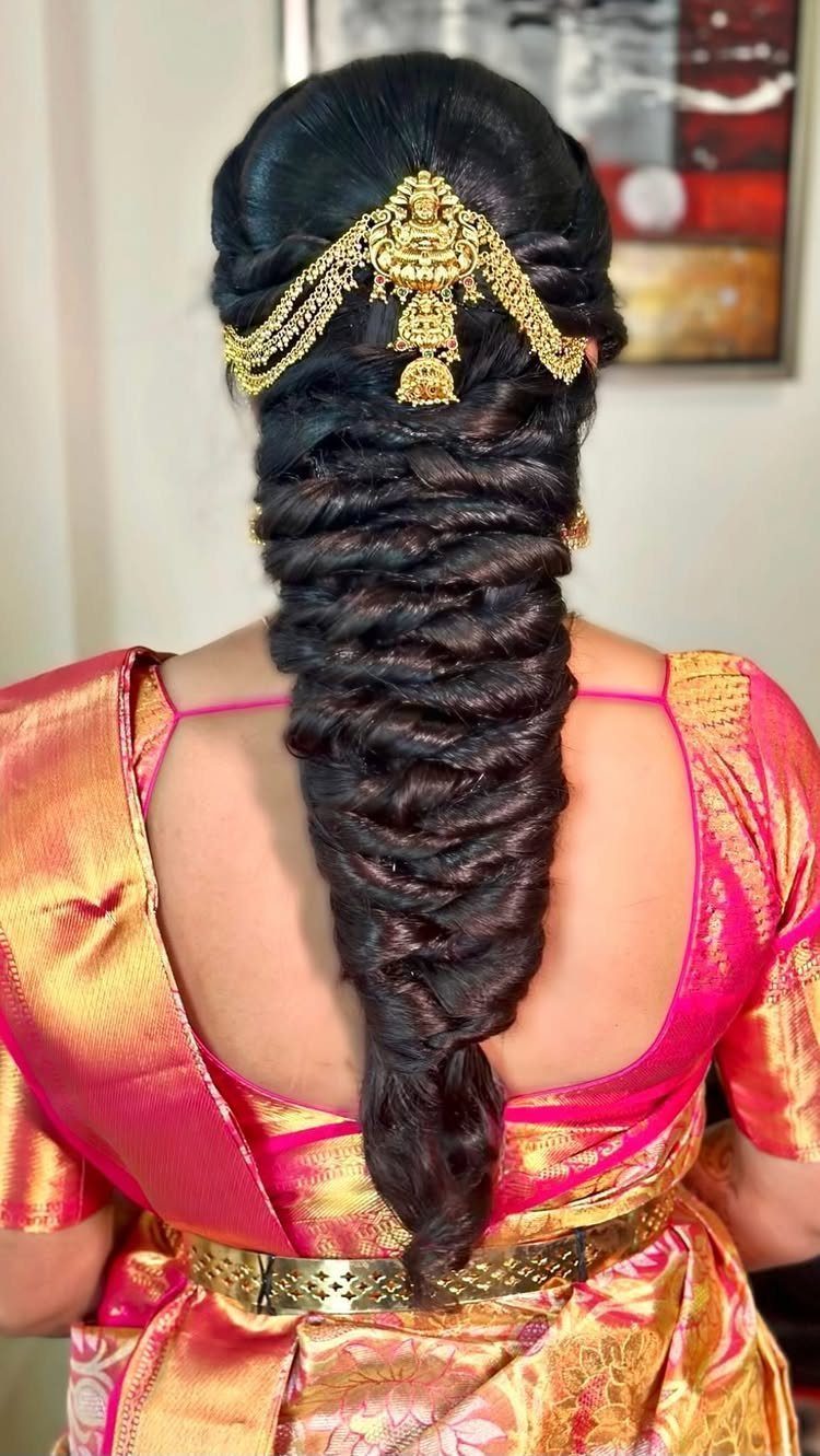 Voluminous textured black braid adorned with gold jewelry on a woman in saree
