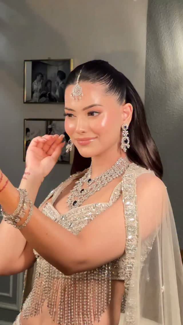 Woman in cream bridal lehenga with glowing makeup and peach blush on cheeks