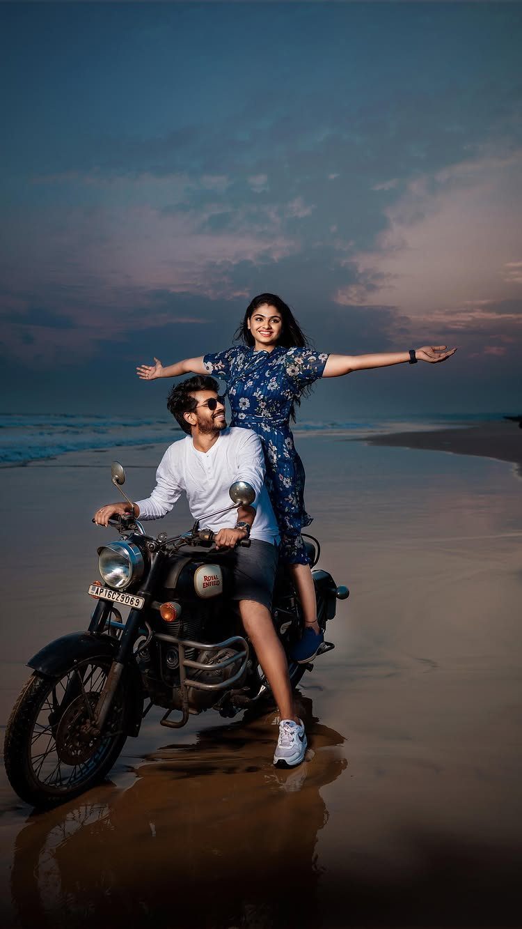 Couple posing on a motorcycle on a beach during a pre-wedding shoot.