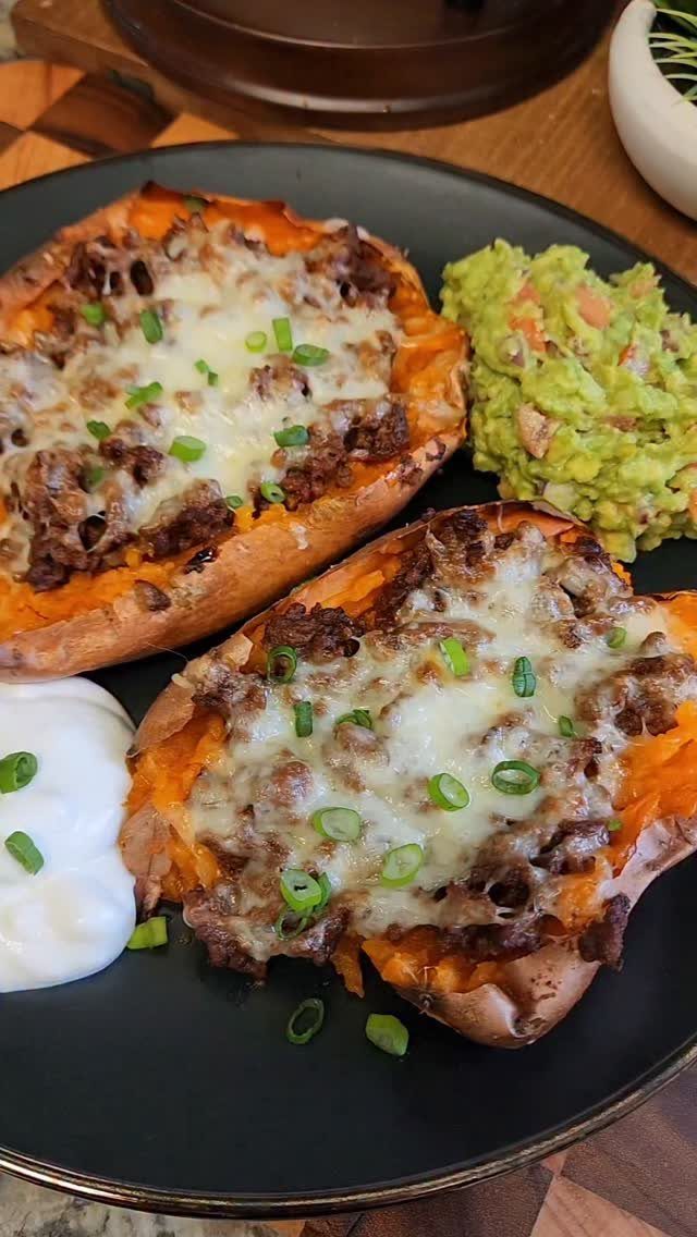 Stuffed sweet potatoes with ground meat and cheese served with guacamole and sour cream.