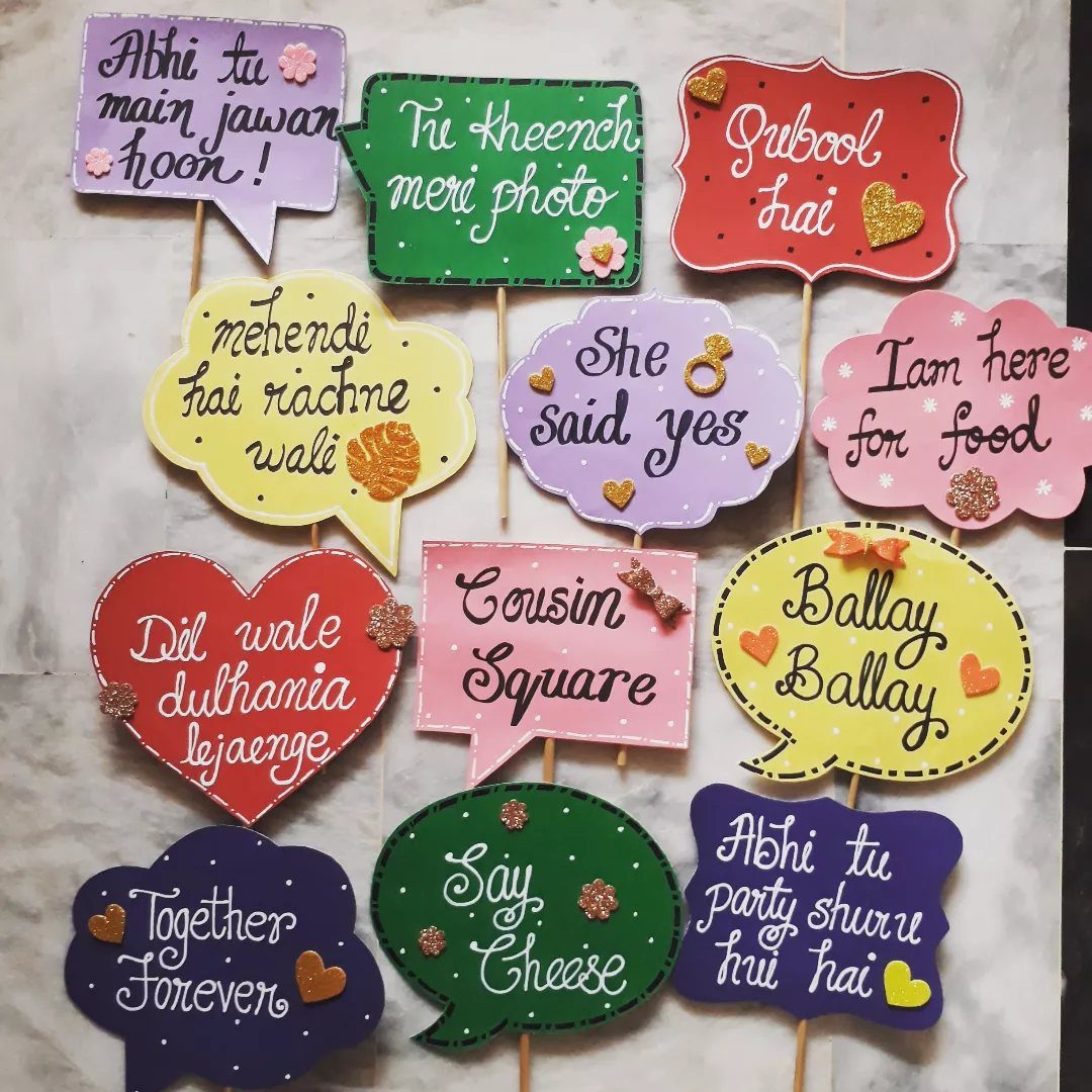 Colorful handheld photo booth props with romantic and funny phrases on sticks.