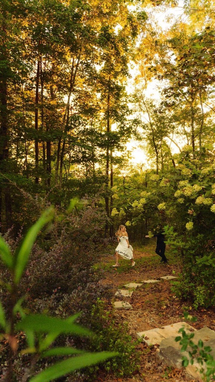 Bride and groom walking on a stone path through a golden autumn forest