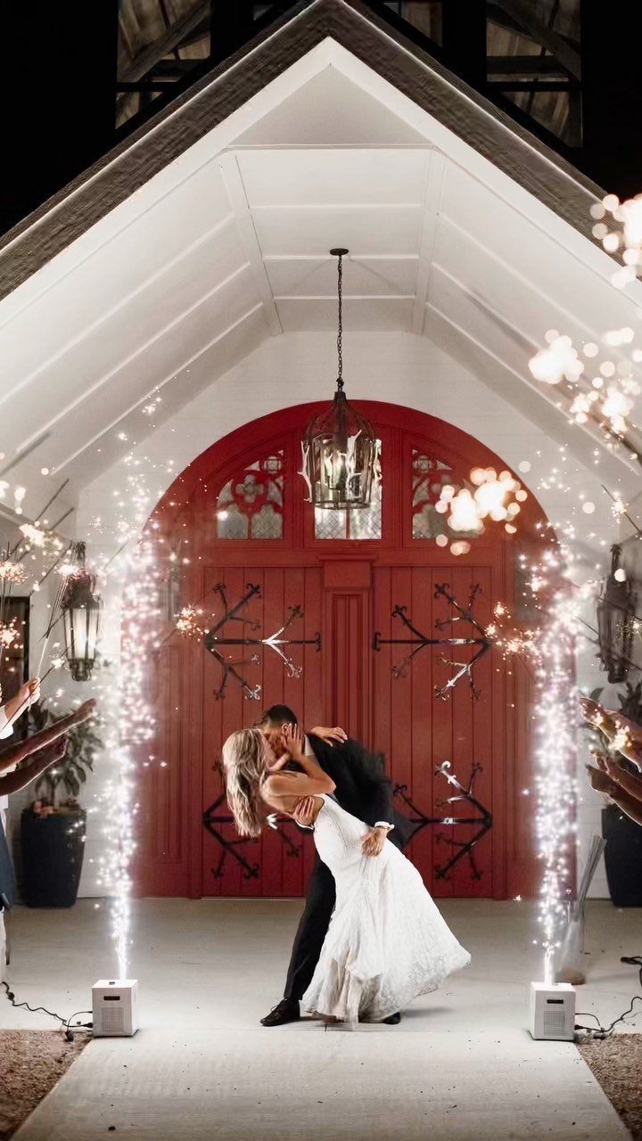 Bride and groom kissing in a dip between two tall sparkler fountains