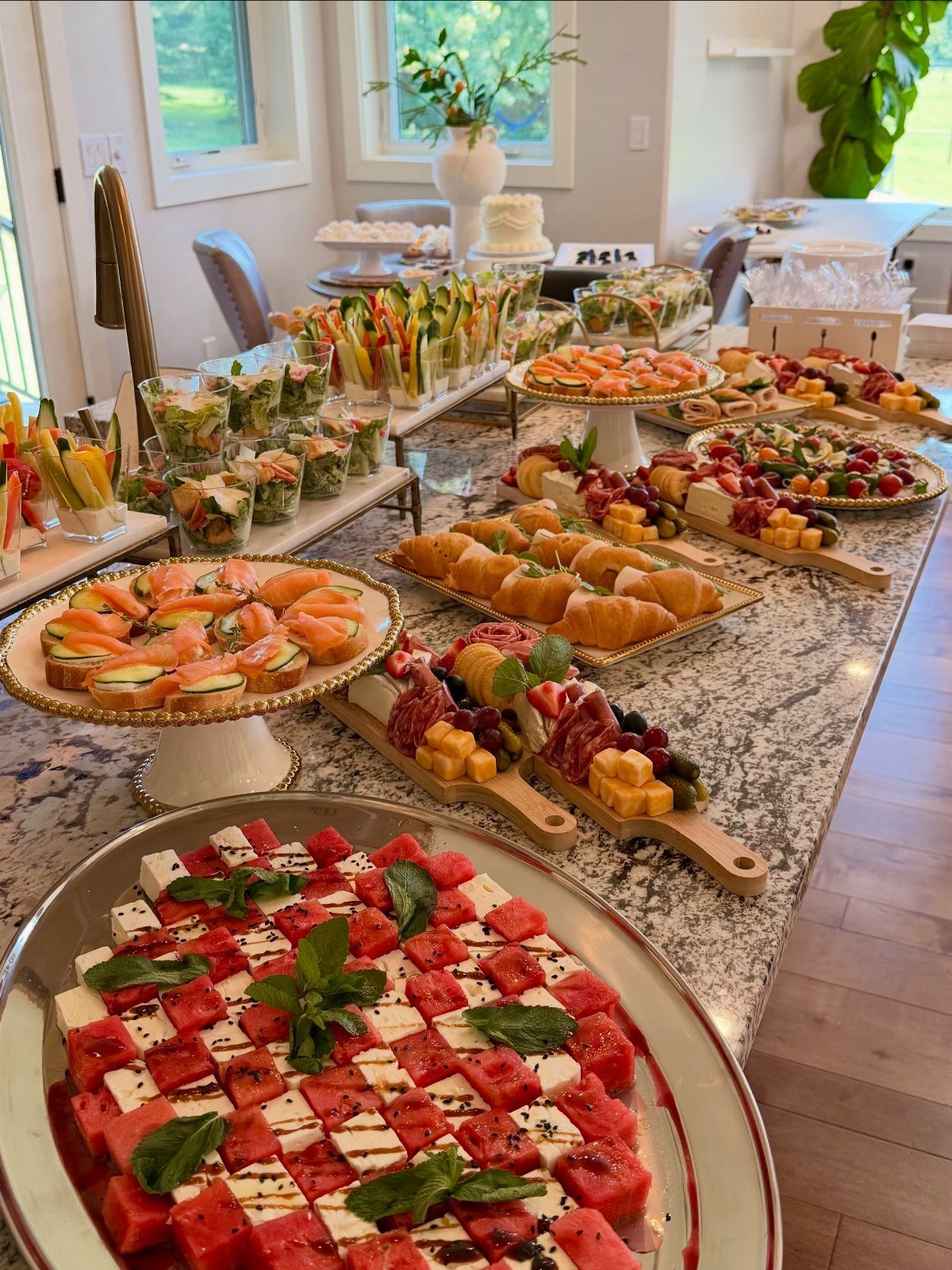 Lavish grazing table spread with watermelon feta, smoked salmon, and charcuterie on granite.