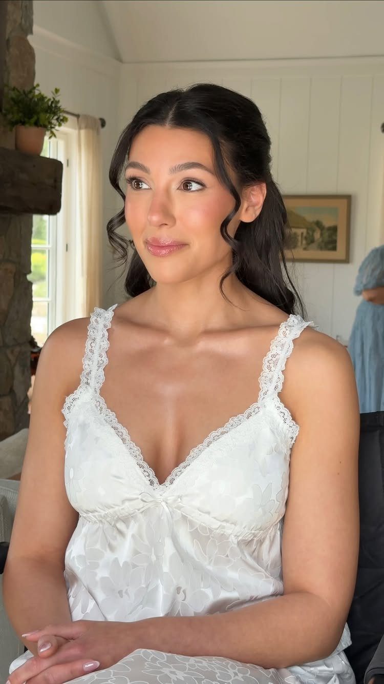 Woman with soft rosy wedding makeup wearing a white lace satin robe