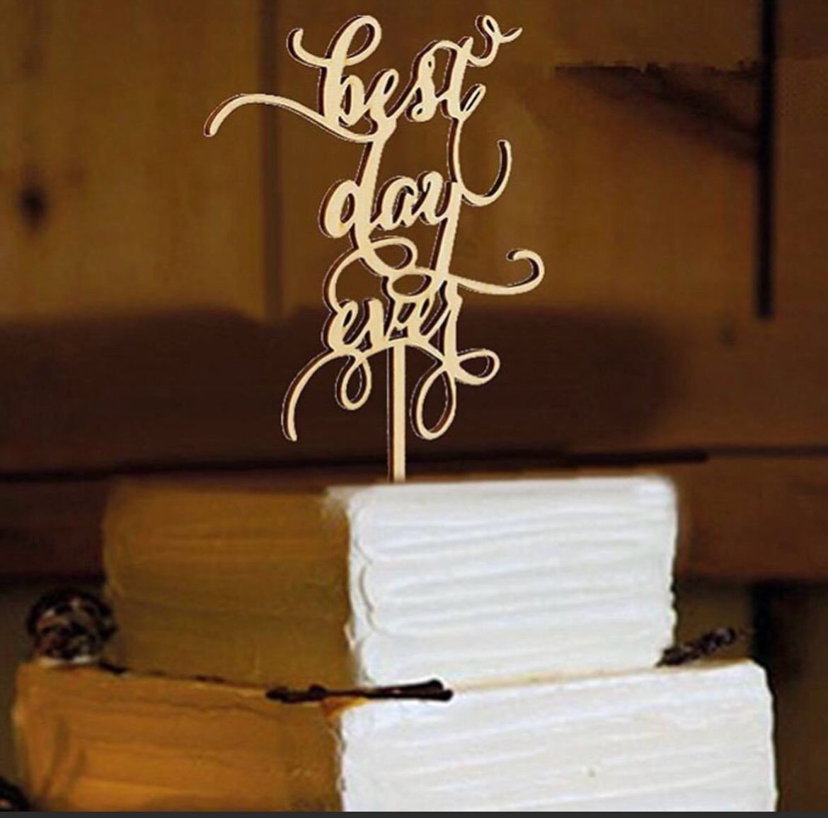Wooden Best day ever cake topper on a white frosted tiered cake
