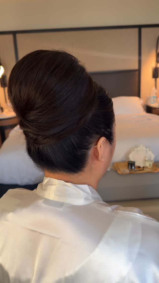 High voluminous beehive updo on a person wearing a white satin robe.
