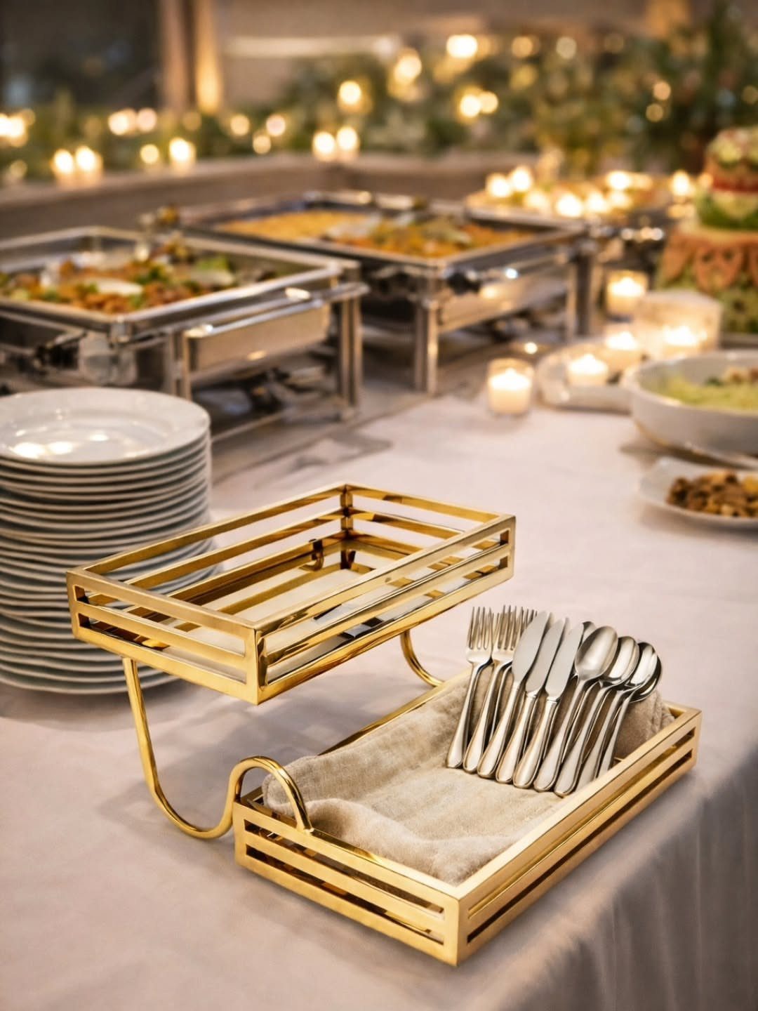 Silver cutlery in a gold tiered holder on a wedding buffet table