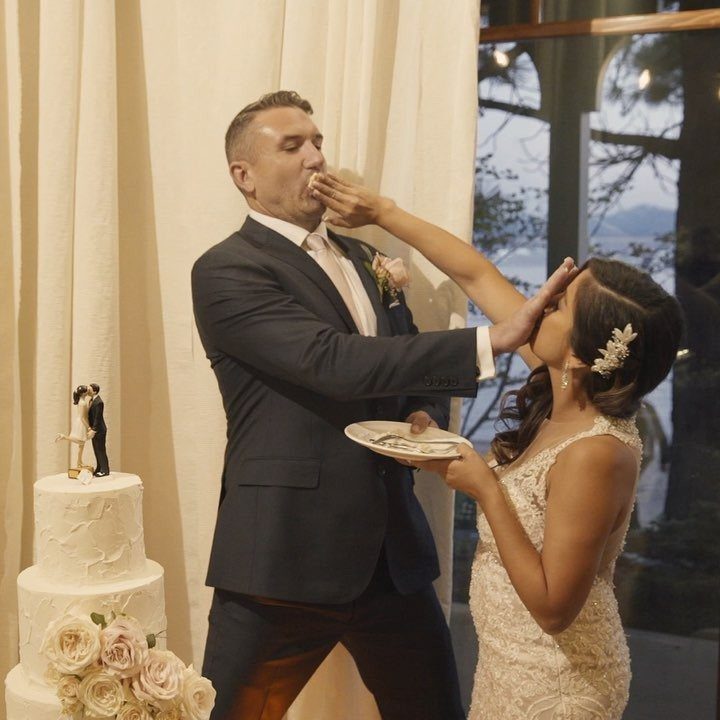Bride feeding a piece of wedding cake to the groom during their reception.