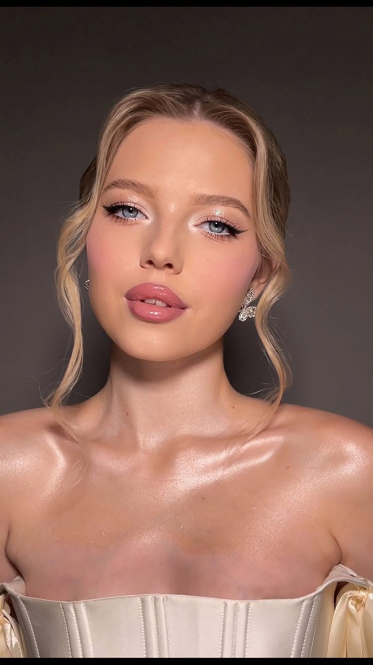 Blonde woman with elegant bridal makeup and white corset dress posing for portrait