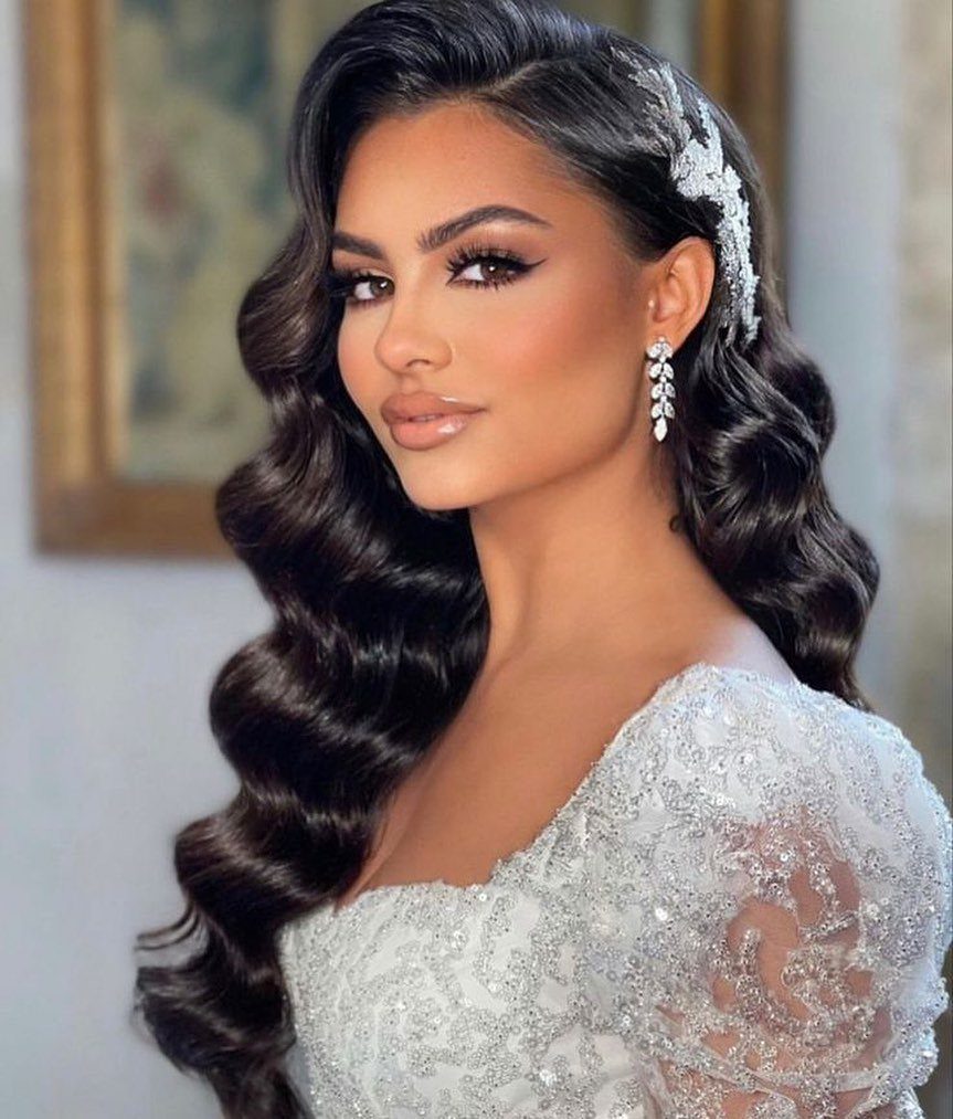 Woman with glamorous dark Hollywood waves wearing a white beaded wedding dress.