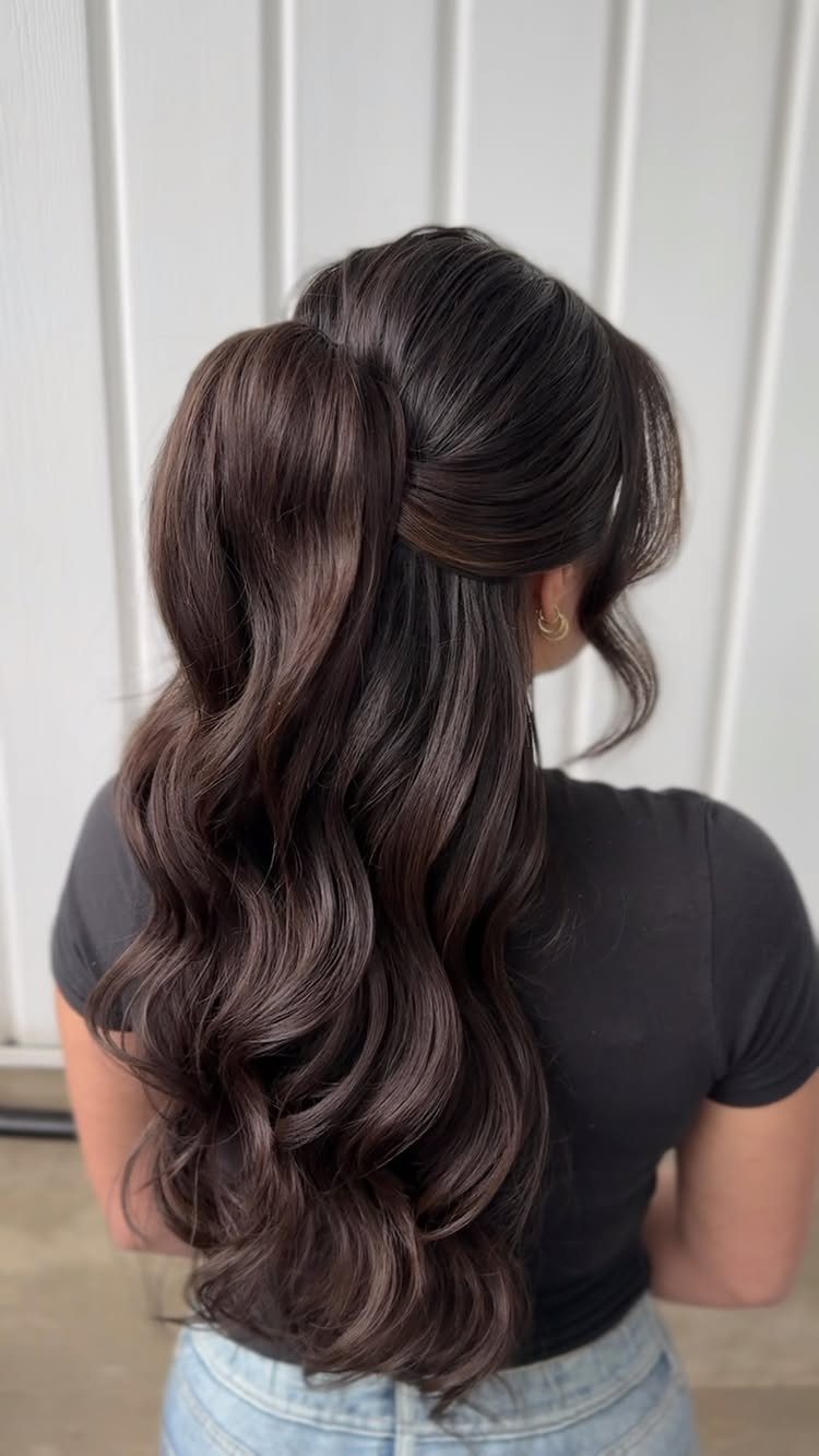 Long wavy brown hair styled in a half-up, half-down wedding hairstyle.
