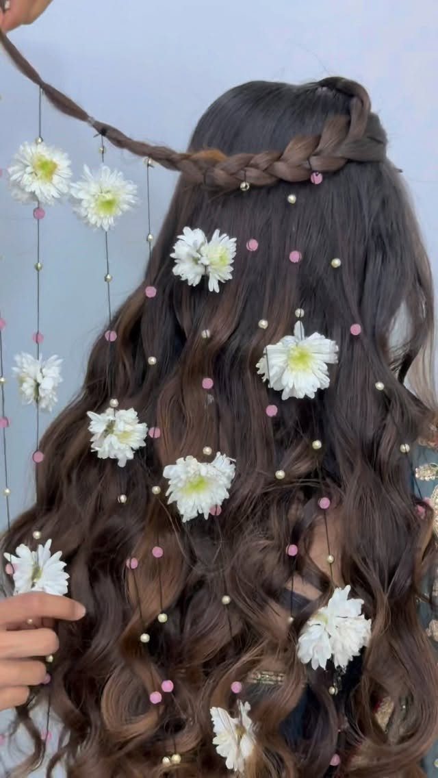 Wavy brown hair with a braided crown decorated with white flowers and beads