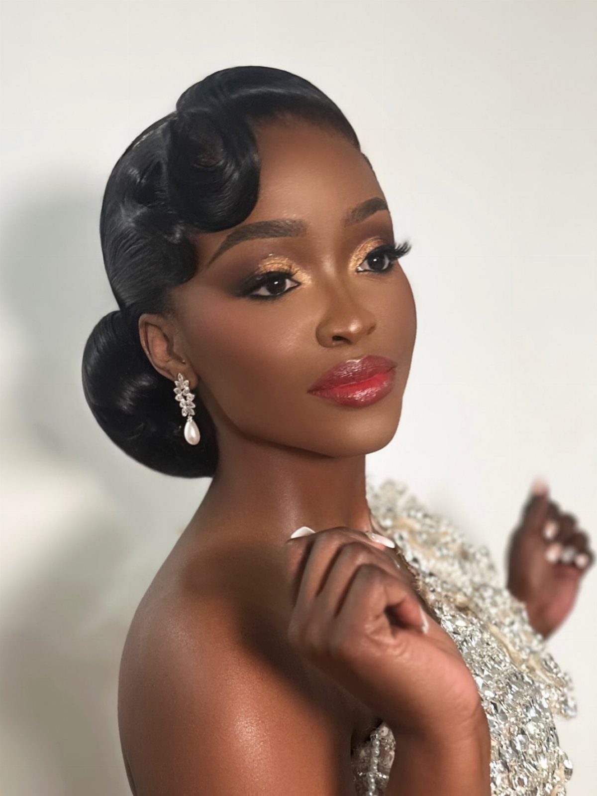 Woman with a polished low chignon updo and shimmering silver sequined dress