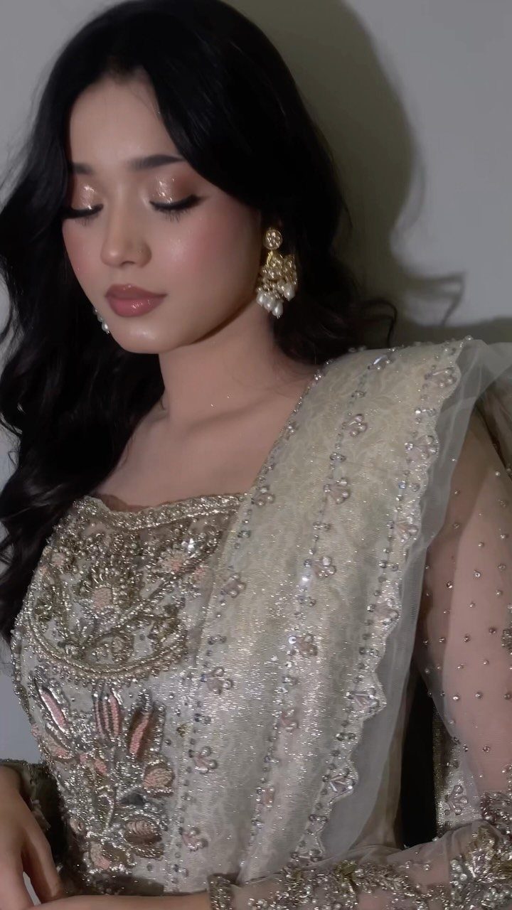 Woman in white embellished dress with soft glam makeup and shimmering eyeshadow