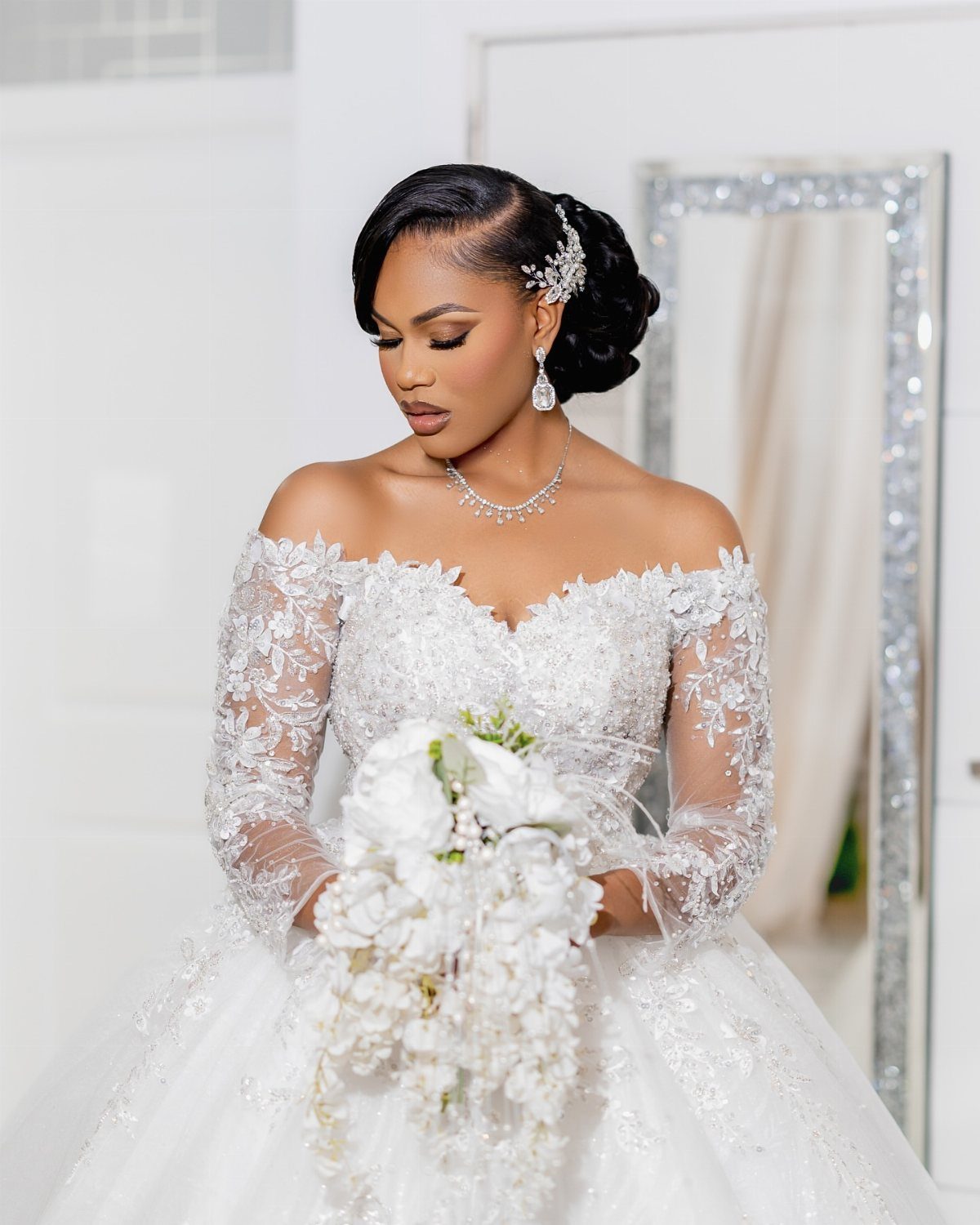 Bride in a white lace wedding gown holding a white floral bouquet